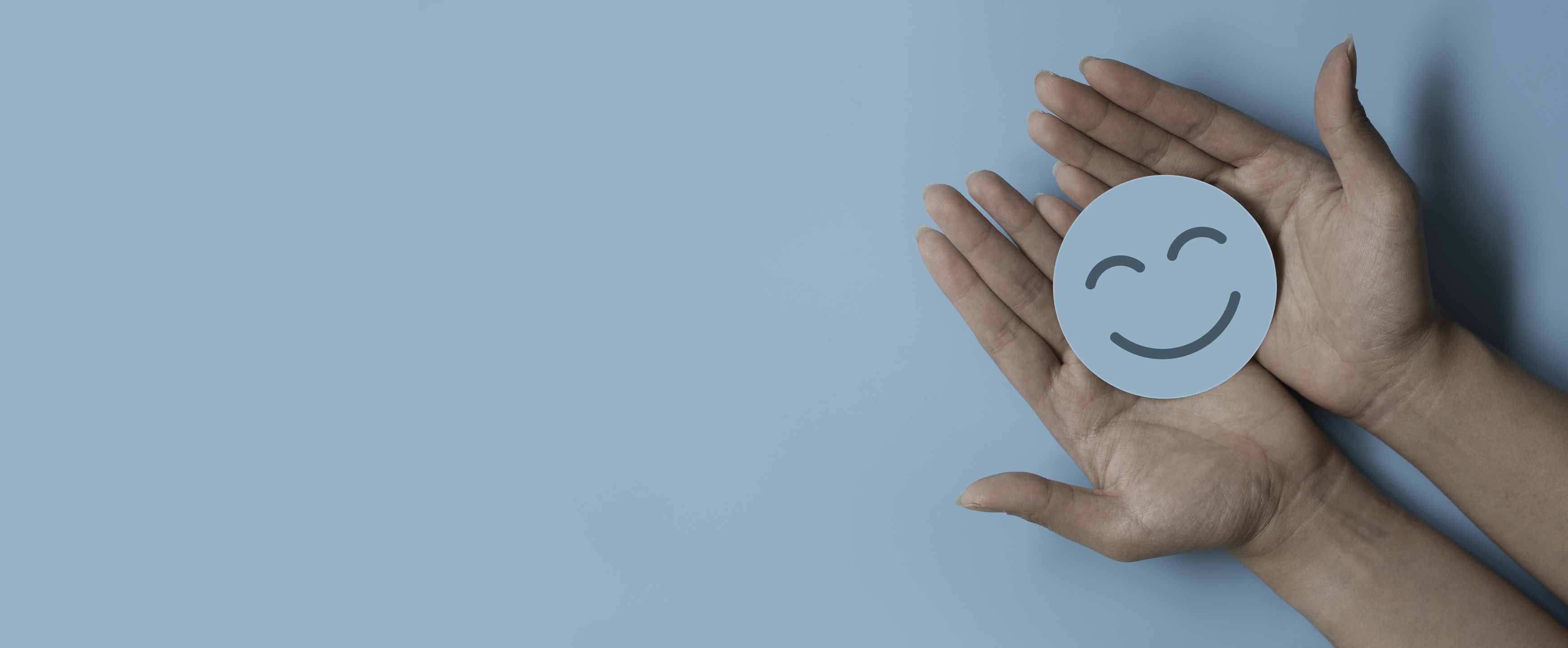 Smiling face paper circle held in two palms