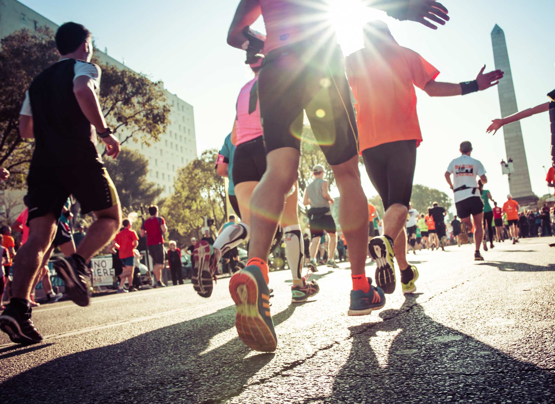 Sole of foot up with group of runners on tarmac road in London marathon