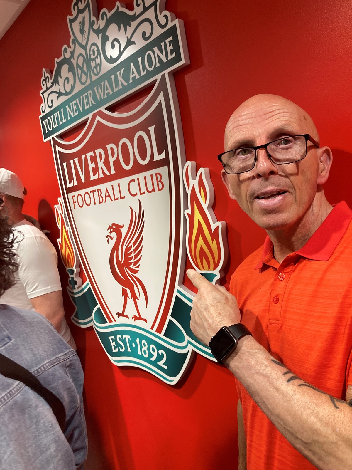 Paul with Liverpool FC badge behind him on the wall