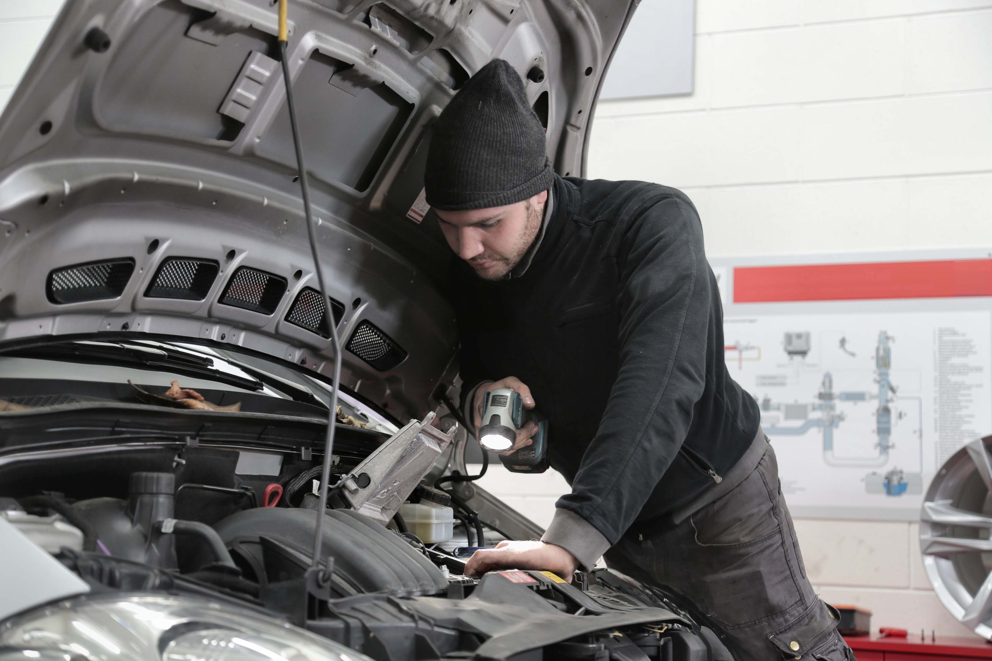 Garage technician looking at a car engine to diagnose issue. Demonstrating skills that can be used in other job roles, sectors and industries.