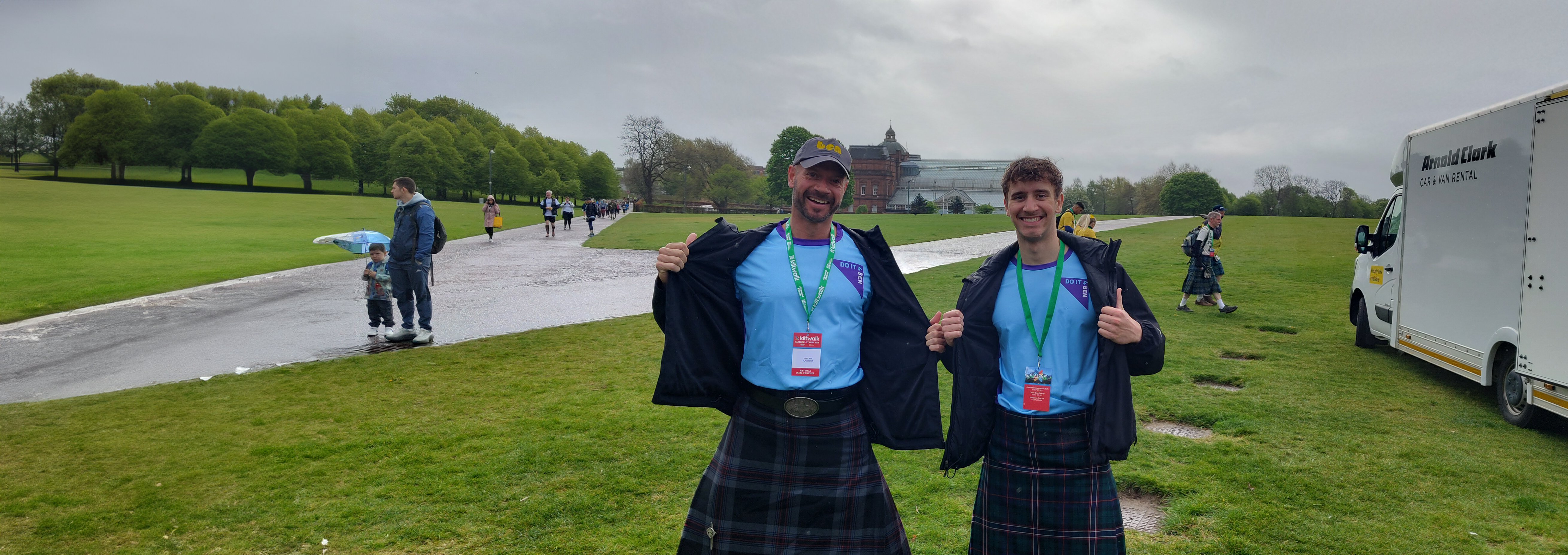 Two men walking the Kiltwalk for Ben in branded clothing and a green and black kilt - getting ready to trek