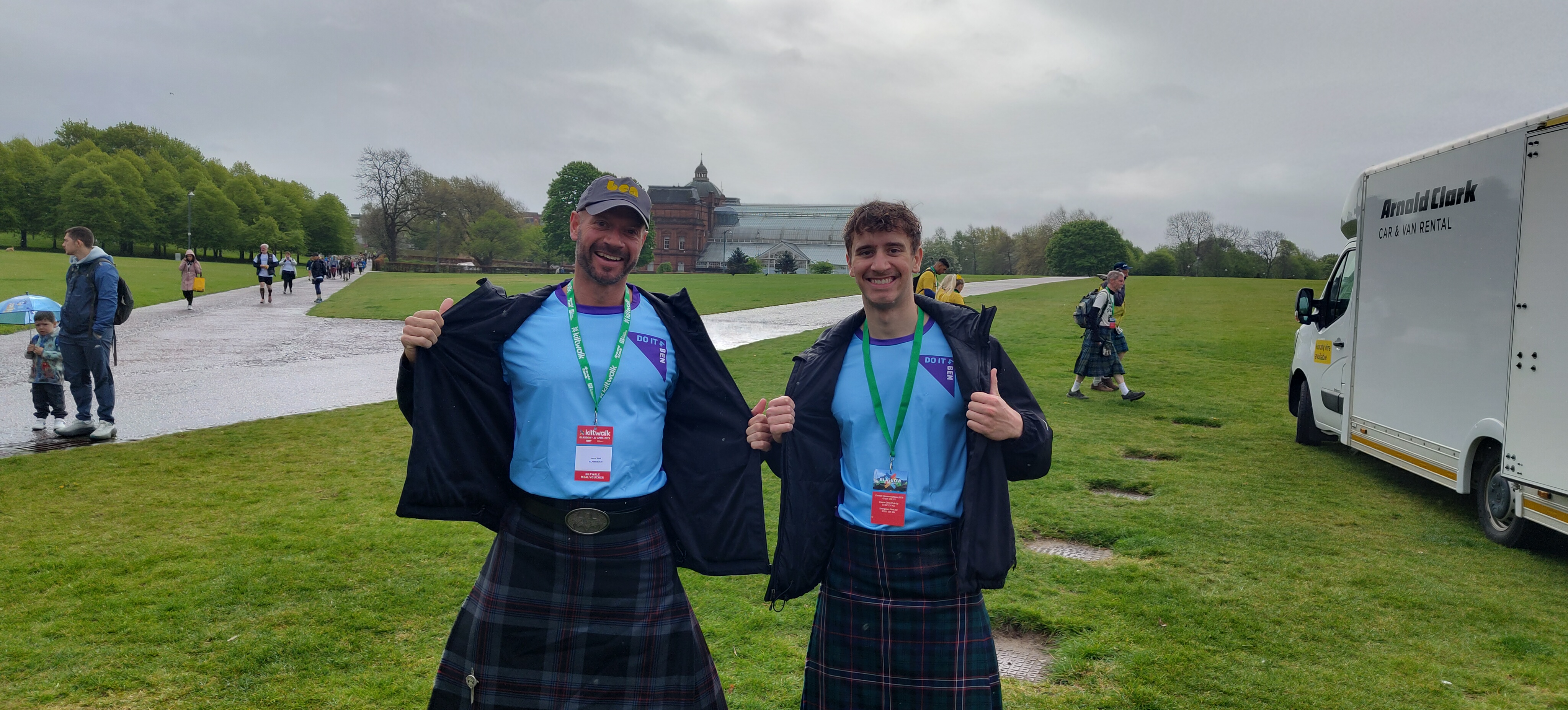 Two men walking the Kiltwalk for Ben in branded clothing and a green and black kilt - getting ready to trek