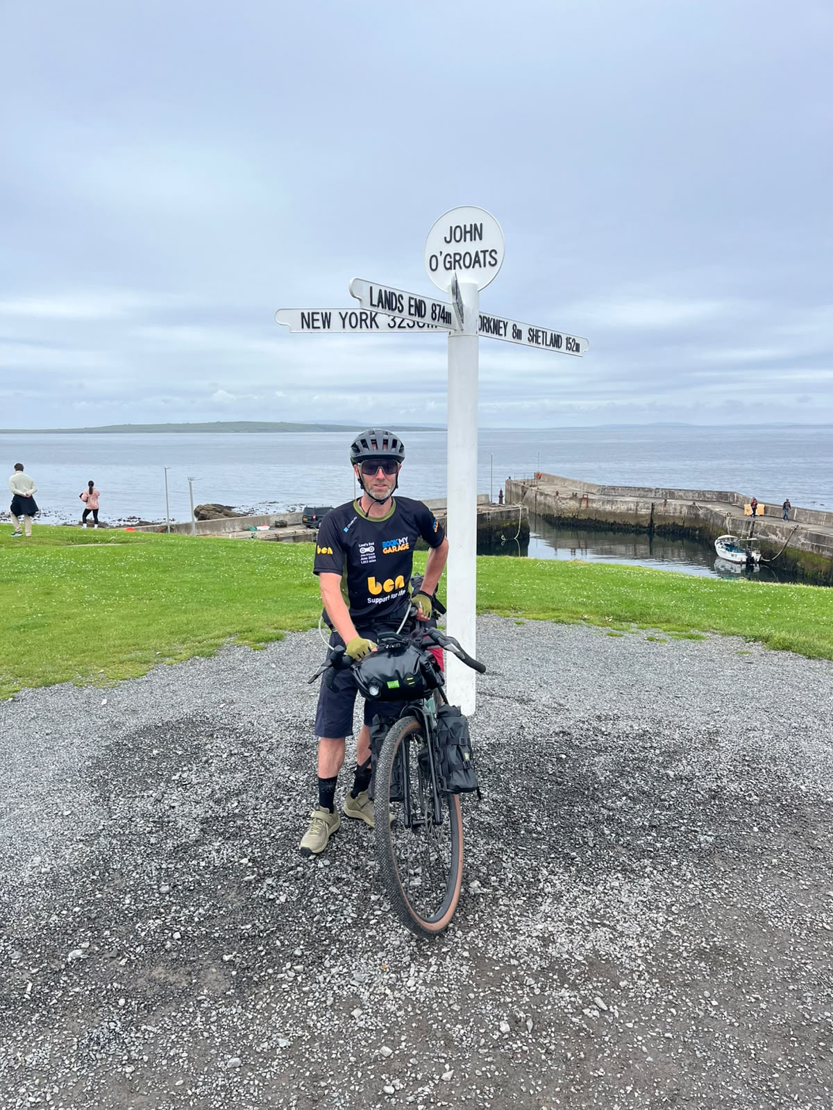Ollie standing in front of John O'Groats sign