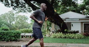 Person running down a street to boost their physical health