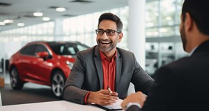 Customer signing documents in car dealership