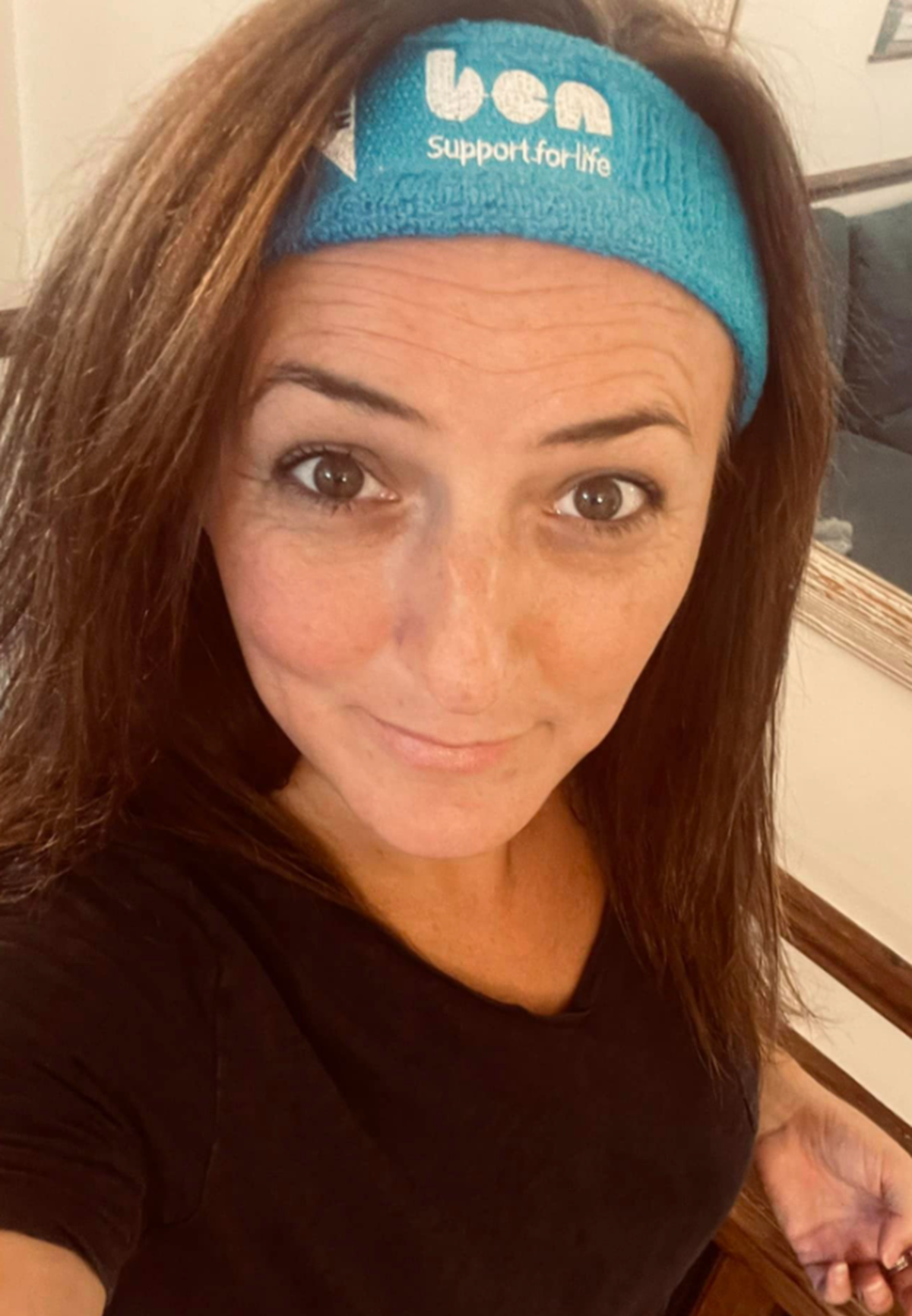 Selfie of a woman wearing a turquoise Ben 'support for life' headband and a black T-shirt.