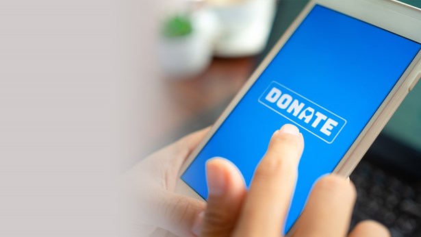 A finger tapping a 'Donate' button on a smartphone screen.