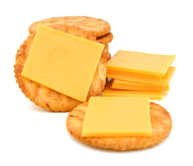 photograph of squares of cheese on small round cracker biscuits