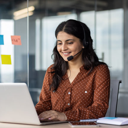 Online support worker at workplace, woman using headset phone for video call, business woman typing on computer keyboard.