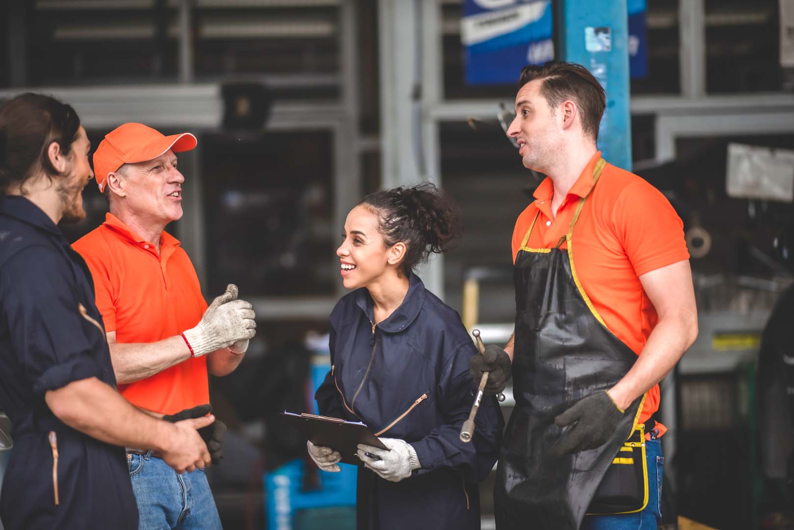 Mechanic team smiling at each other in garage setting