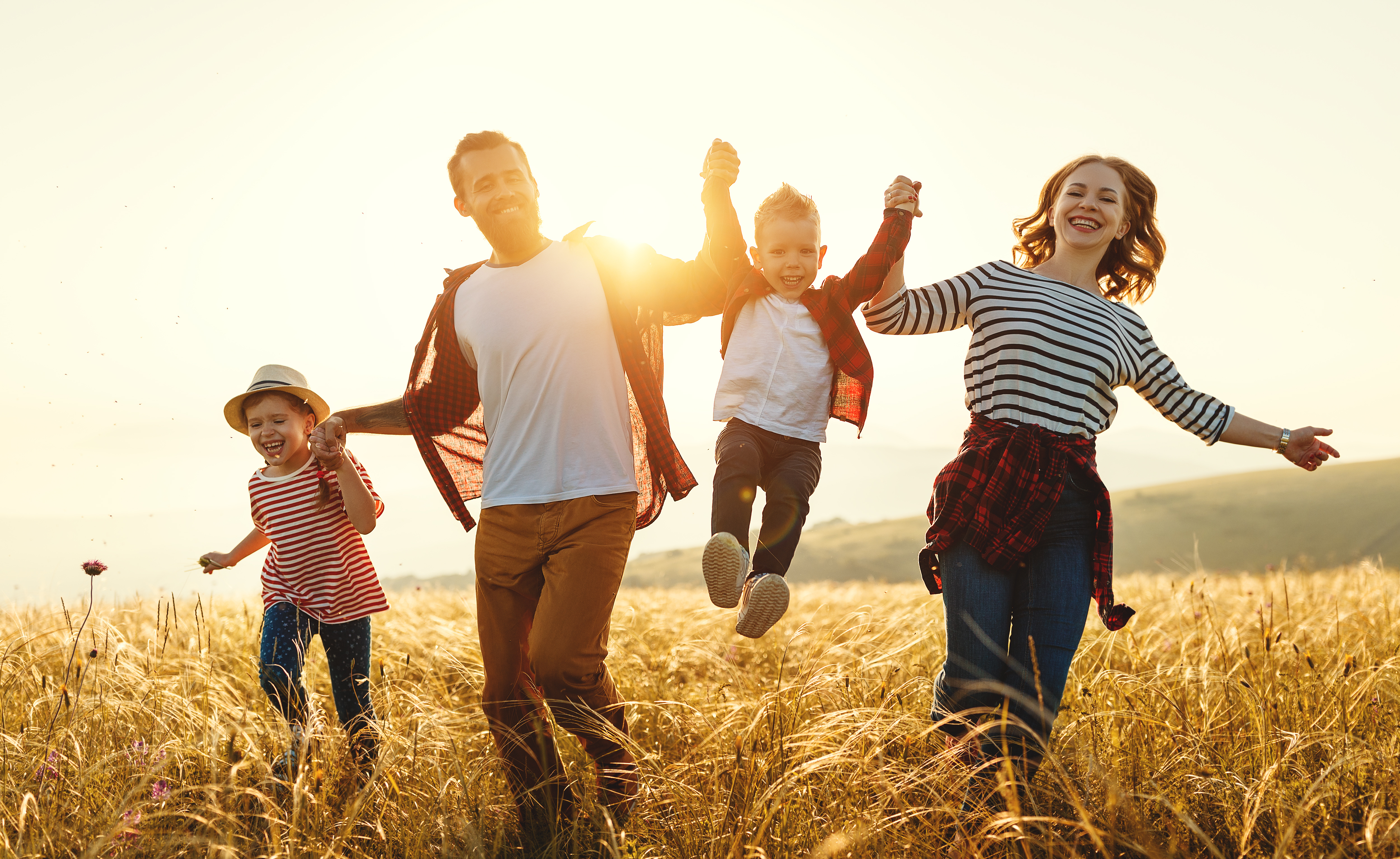 Happy family with children in nature at sunset