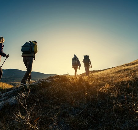 Group of four hikers, walking up a mountain in England at sunset