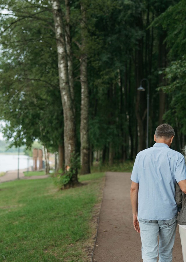 Two people walking together with their arm around each other showing support