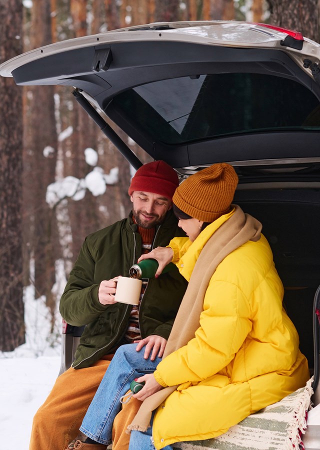 man and woman in the car in snow