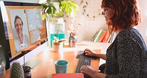 Happy lady working from home on computer having a video call in a light and welcoming home office environment. Tips for working at home