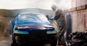 Car painter paints a car with a spray gun. Car painting at home.