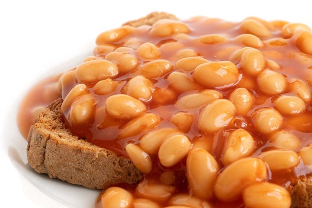 baked beans piled high on a slice of toast and spilling over the edges