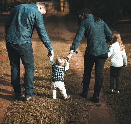 A family spending time together in nature walking down a woodland path